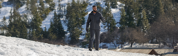 a man standing in the snow, wearing winter workwear