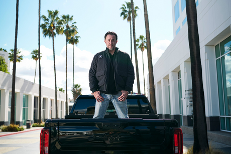 Person on the back of a truck wearing Strauss x Stuntsmen wear