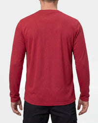 A model wears the STRAUSS Performance Long Sleeve Shirt in fire red with tan work pants and work boots, showing the shirt fit