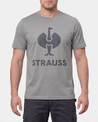 A model wears the STRAUSS T-Shirt e.s.concrete in pearl gray with work pants and work boots in a studio product scene