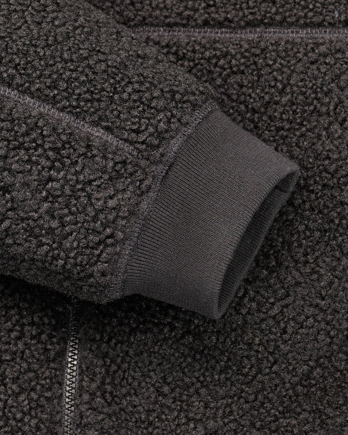 Close-up of zippered pocket details on STRAUSS e.s.e:pic hooded sherpa fleece jacket in black