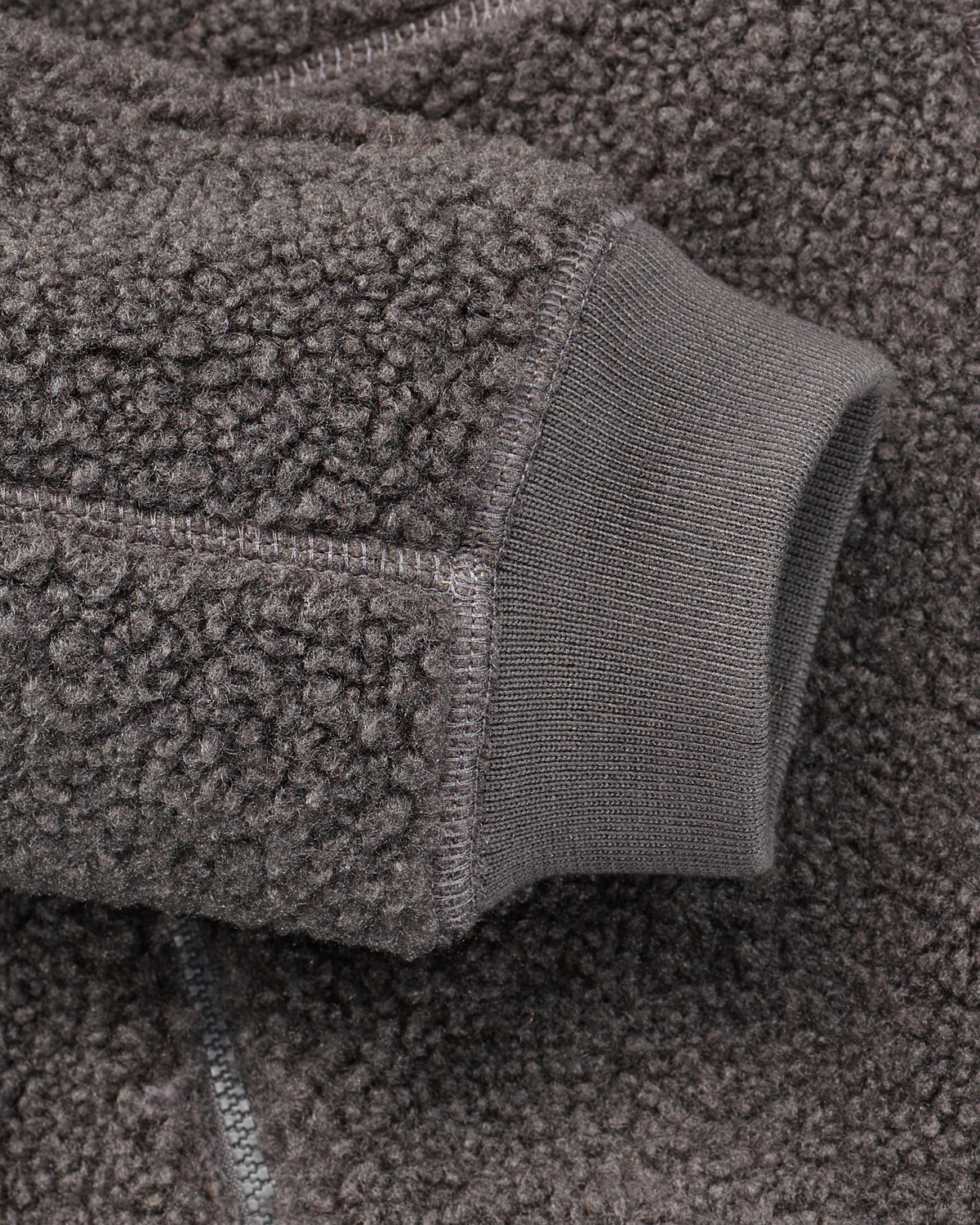 Close-up of zippered pocket details on STRAUSS women's e.s.e:pic hooded sherpa fleece jacket in carbon gray