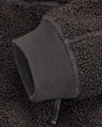 Close-up of zippered pocket details on STRAUSS kids' e.s.e:pic sherpa fleece jacket in black
