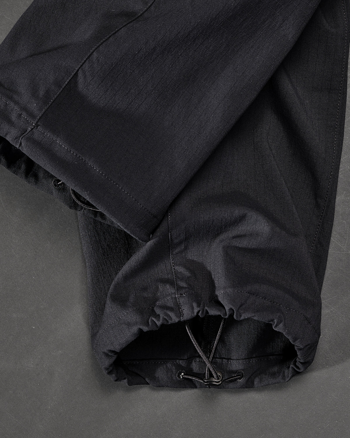 Close-up of adjustable hem pocket details on Stretch Ripstop Cargo Work Pants e.s.taktik in black