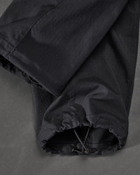 Close-up of adjustable hem pocket details on Stretch Ripstop Cargo Work Pants e.s.taktik in black