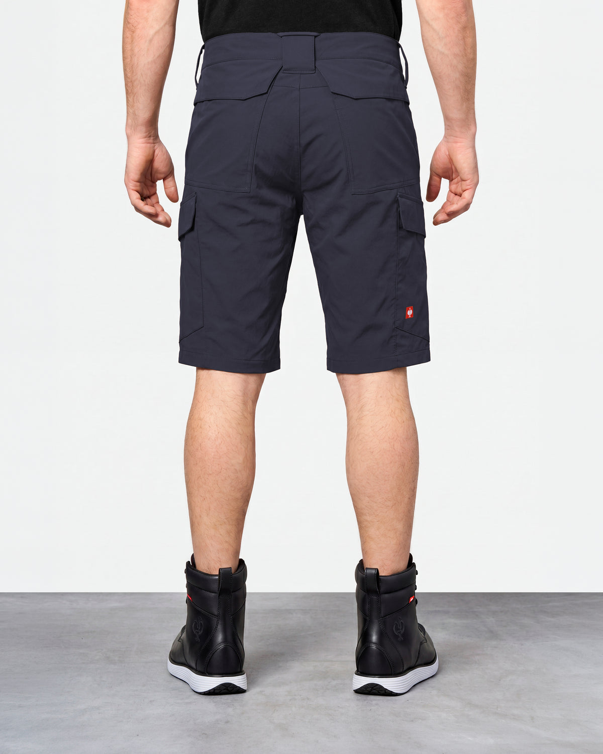 Alternate model view of Engelbert Strauss e.s. taktik stretch ripstop cargo work shorts in nero blue, showing the side and back fit with visible utility pocket placement and workwear construction.