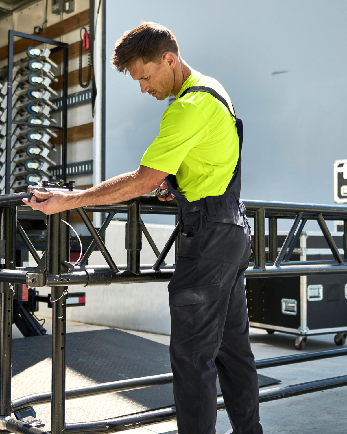 black STRAUSS Stretch Ripstop Cargo Work Bib Overall e.s.taktik shown in use at a jobsite
