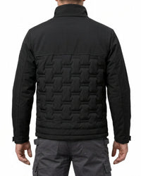 A man viewed from the back wearing a black quilted jacket with a distinctive geometric patterned back panel and dark gray cargo pants, set against a plain white background.