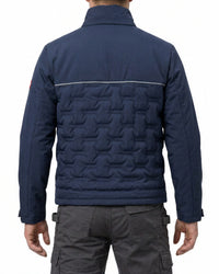 A man viewed from the back wearing a navy blue quilted jacket with a textured geometric pattern on the lower back and dark gray cargo pants, against a plain white background.