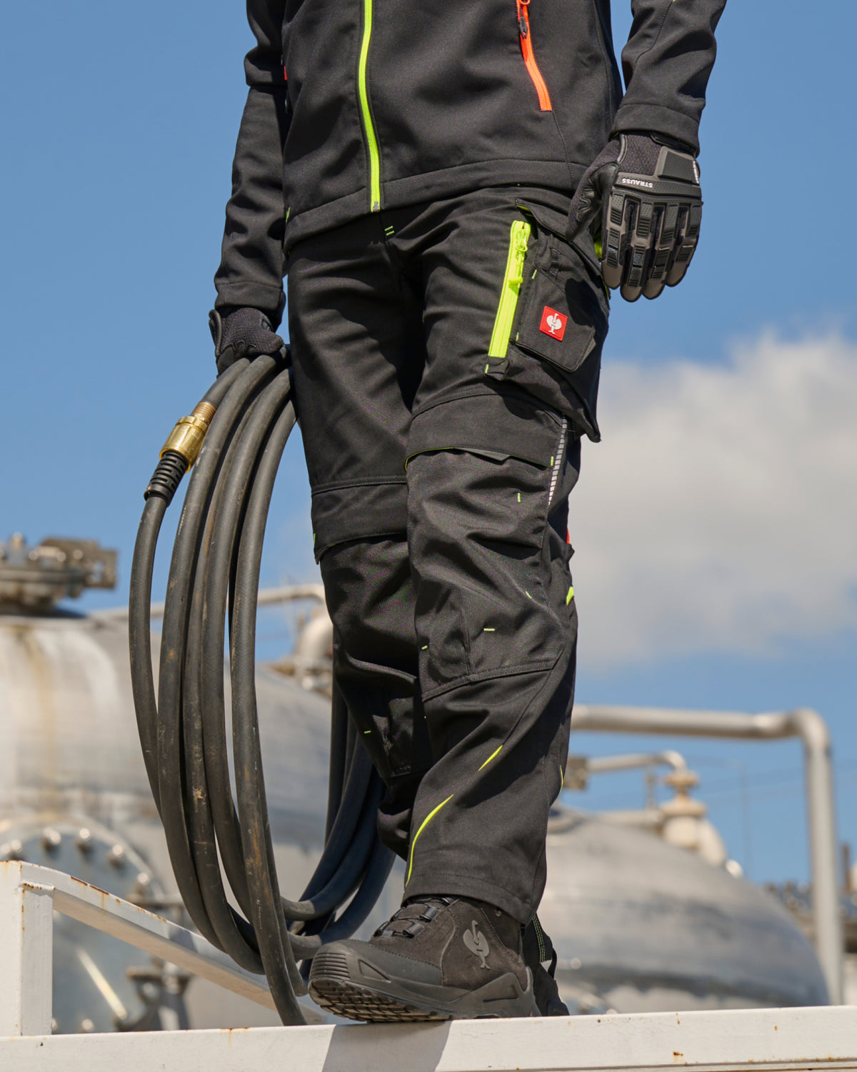 Cargo Work Pants e.s.motion 2020 in black/high-vis yellow-orange worn in a work setting