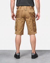 A man viewed from the back wearing tan cargo shorts, a dark gray t-shirt, and black sneakers, standing against a white studio background.