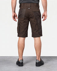 A man viewed from the back wearing dark brown cargo shorts, a dark gray t-shirt, and black sneakers, standing against a light gray studio background.