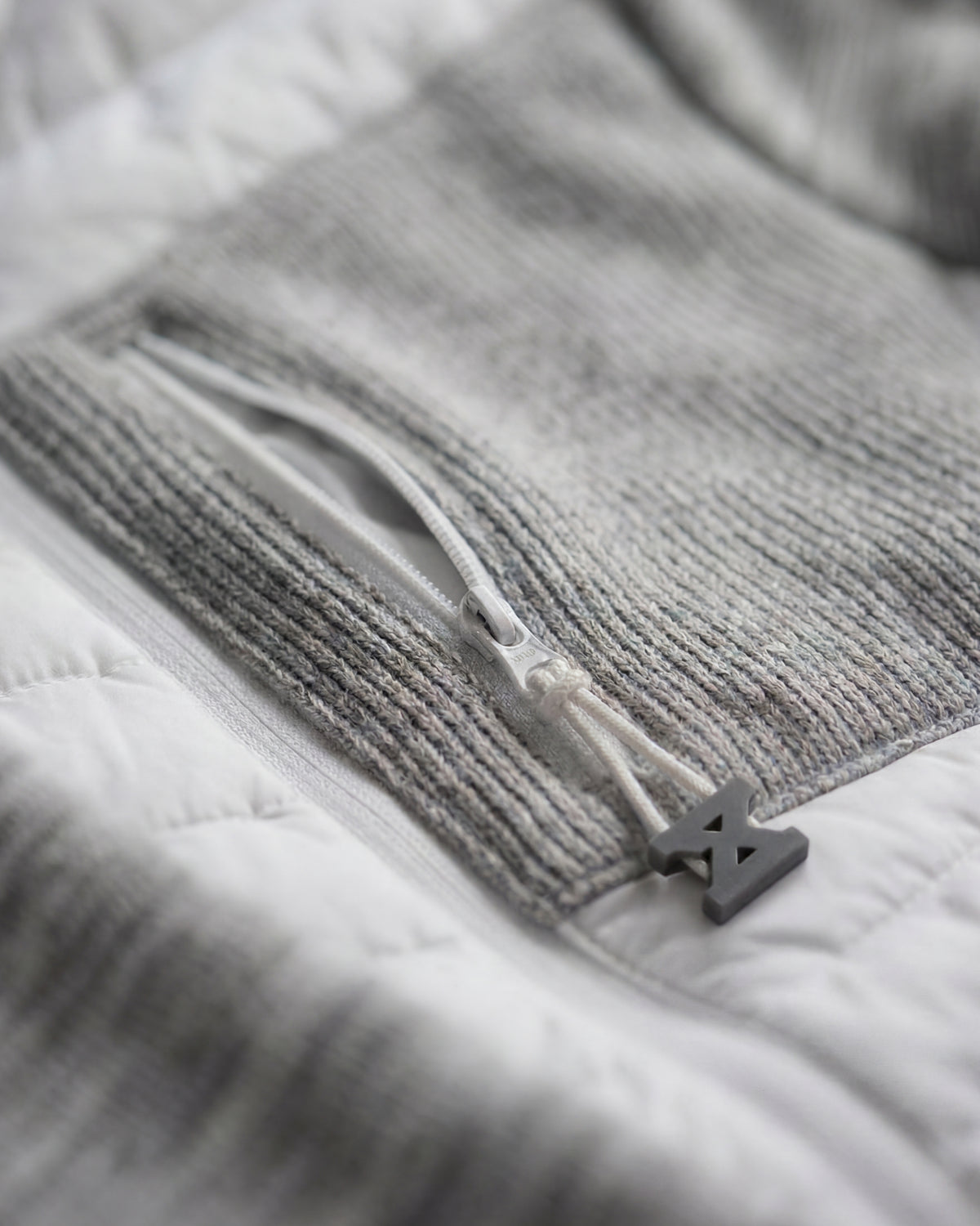 Close-up of quilted and stretch panel details on STRAUSS e.s.motion ten hybrid hooded jacket in white melange