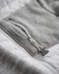 Close-up of quilted and stretch panel details on STRAUSS e.s.motion ten hybrid hooded jacket in white melange