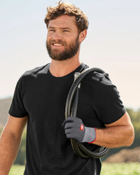 A close work scene shows black and gray STRAUSS evertouch micro nitrile foam gloves protecting hands during a task.