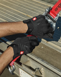 A close work scene shows black STRAUSS e.s.trail light graphic mechanic gloves protecting hands during a task.