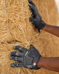 A close work scene shows black STRAUSS assembly protection gloves protecting hands during a task.