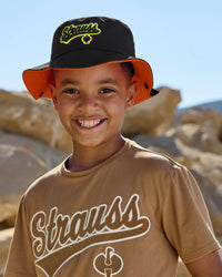 A worker wears a black STRAUSS kids' e.s.e:pic bucket hat with a work shirt and utility pants outdoors.
