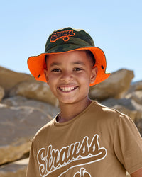 A model wears a camouflage STRAUSS kids' e.s.e:pic bucket hat with a casual STRAUSS workwear outfit.