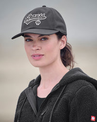 A worker in a carbon gray STRAUSS e.s.e:pic cap stands near jobsite materials in outdoor workwear.