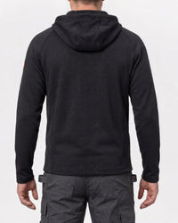 A man viewed from the back wearing a black textured hooded sweatshirt and dark gray cargo pants against a plain white studio background.