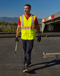 STRAUSS high visibility vest in neon yellow shown on an outdoor jobsite