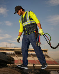 STRAUSS enhanced visibility vest in black shown on an outdoor jobsite