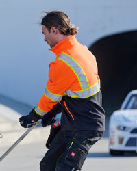 STRAUSS Class 2 high visibility softshell jacket in neon orange and black paired with work pants