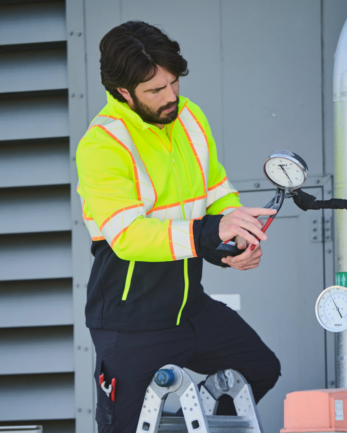 STRAUSS Class 2 high visibility softshell jacket in neon yellow and black in use with workwear