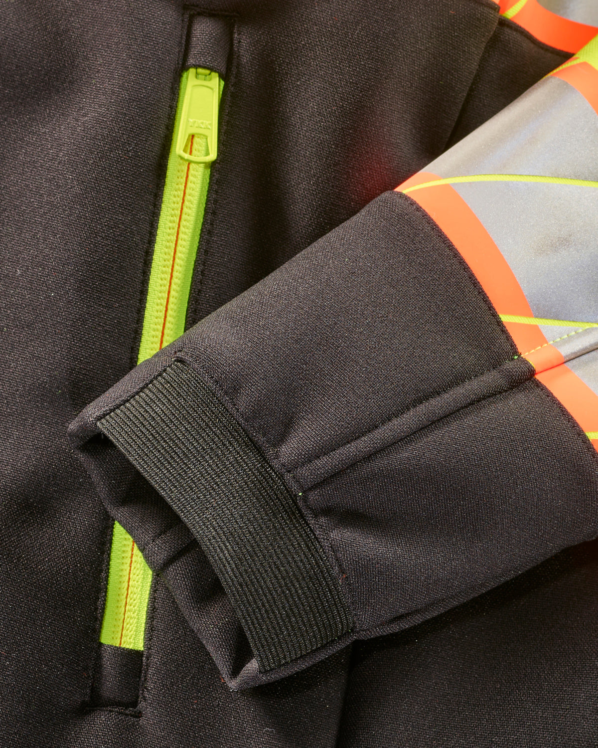 Close-up of zipper and pocket details on STRAUSS Class 2 high visibility softshell jacket in neon yellow and black
