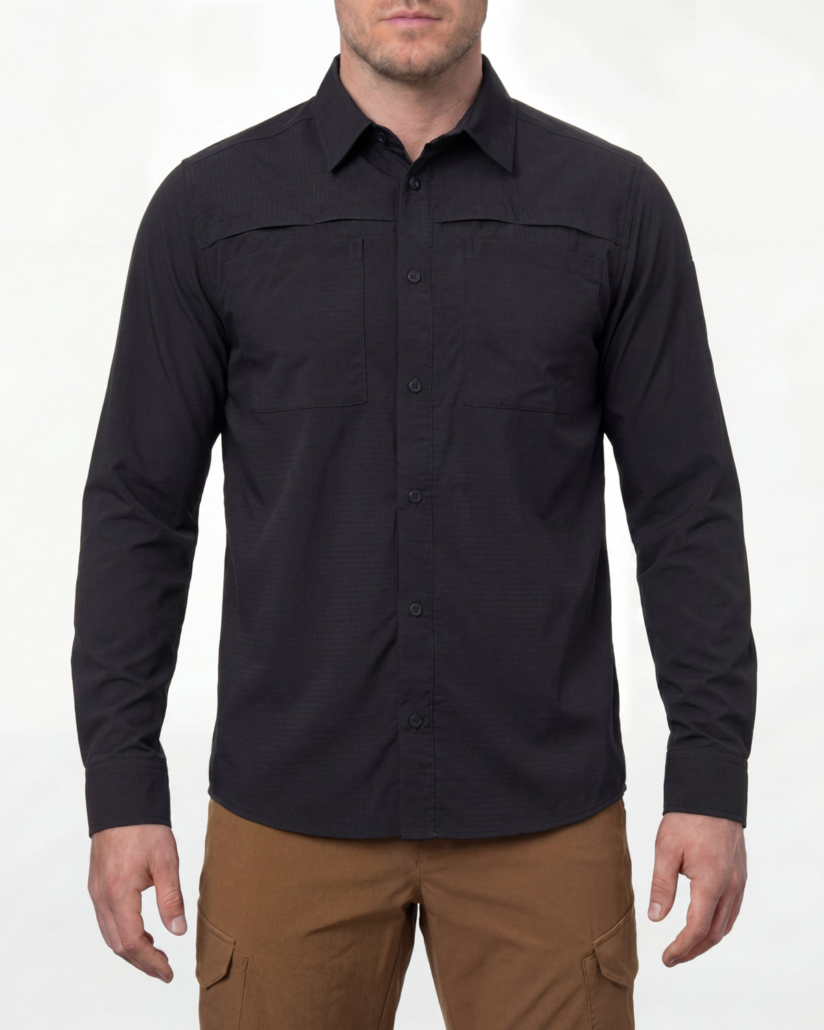 A model wears the STRAUSS e.s.taktik Stretch Ripstop Long Sleeve Work Shirt in black open over a T-shirt with work pants and work boots in a studio product scene
