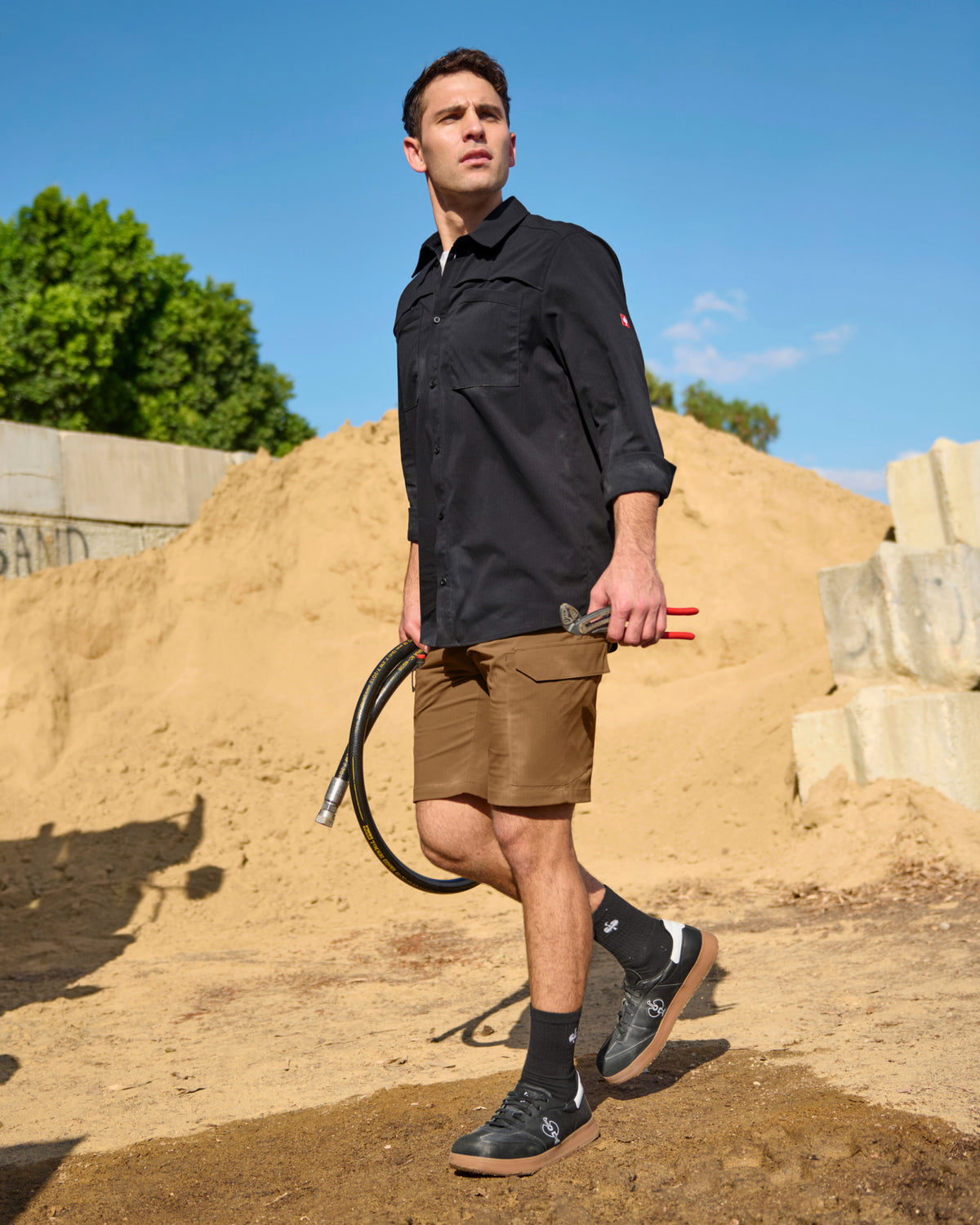 A worker wears the STRAUSS e.s.taktik Stretch Ripstop Long Sleeve Work Shirt in black