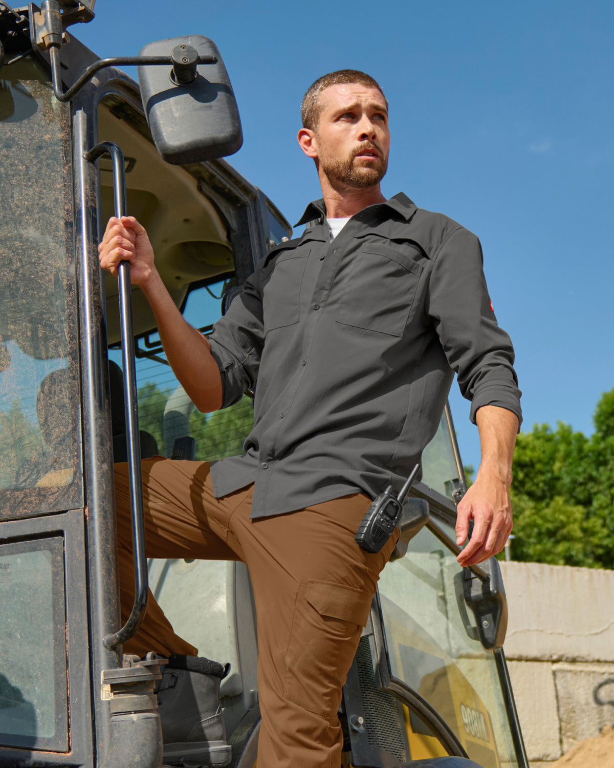 A worker wears the STRAUSS e.s.taktik Stretch Ripstop Long Sleeve Work Shirt in carbon gray