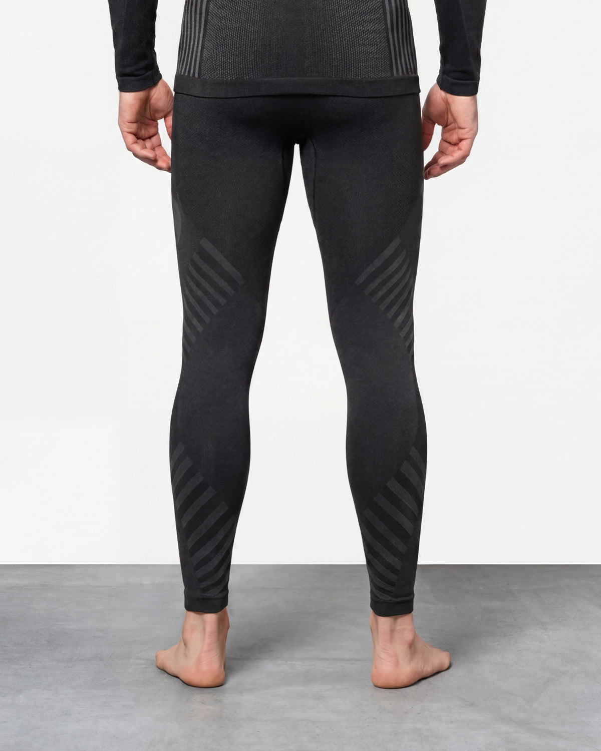 Warm Seamless Thermal Pants e.s.trail pure in black/basalt gray worn by a model, rear view