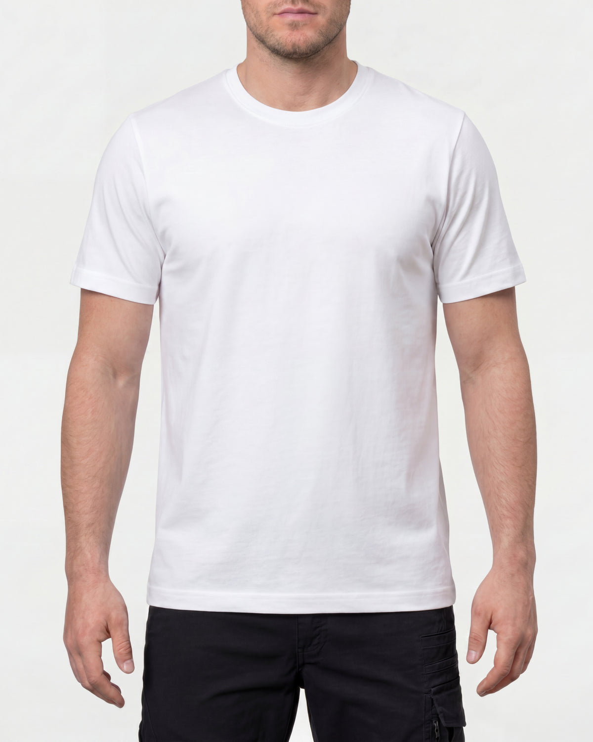 A model wears the STRAUSS Cotton T-Shirt in white with tan work pants and work boots in a studio product scene