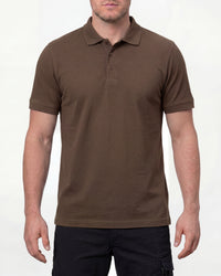A model wears the STRAUSS Cotton Polo Shirt in hazelnut with tan work pants and work boots in a studio product scene