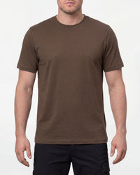 A model wears the STRAUSS Cotton T-Shirt in hazelnut with tan work pants and work boots in a studio product scene
