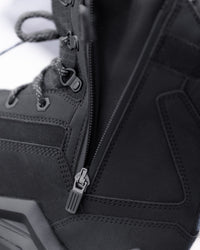 Close-up detail of a black high-top boot showing the side zipper, laces, stitching, and zipper pull hardware.