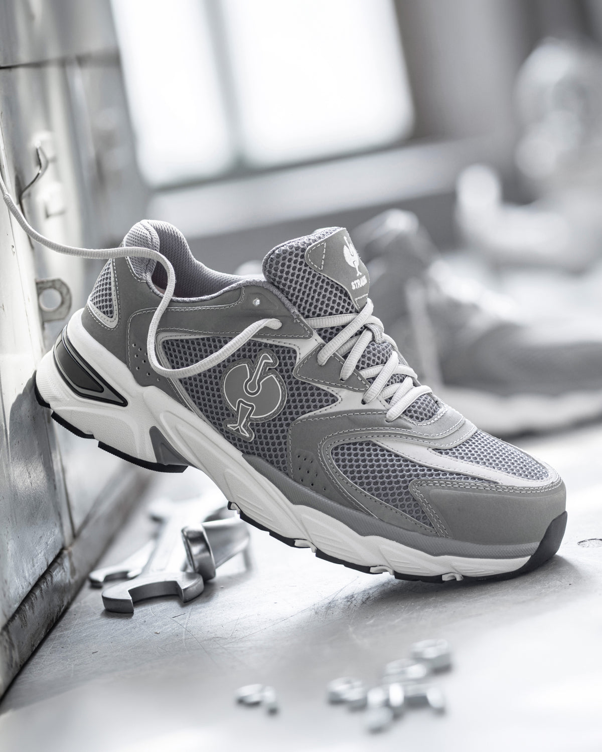STRAUSS St. Louis Composite Toe Work Shoe in Pearl gray shown on rough jobsite ground