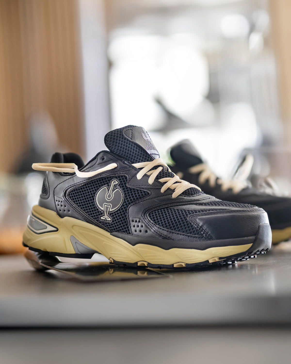 STRAUSS St. Louis Composite Toe Work Shoe in Black and Sand shown on rough jobsite ground