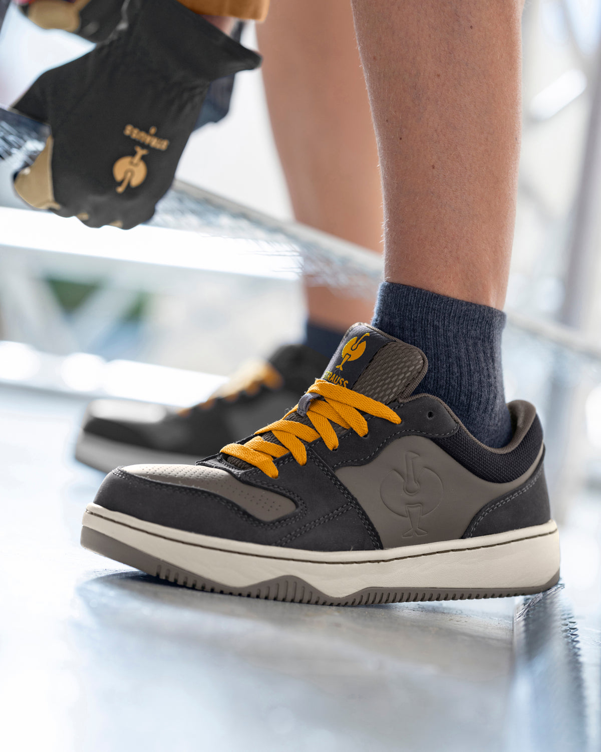 STRAUSS Eindhoven Steel Toe Work Shoe in Nero blue and Stone gray shown on rough jobsite ground