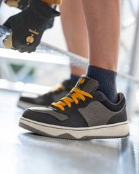 STRAUSS Eindhoven Steel Toe Work Shoe in Nero blue and Stone gray shown on rough jobsite ground
