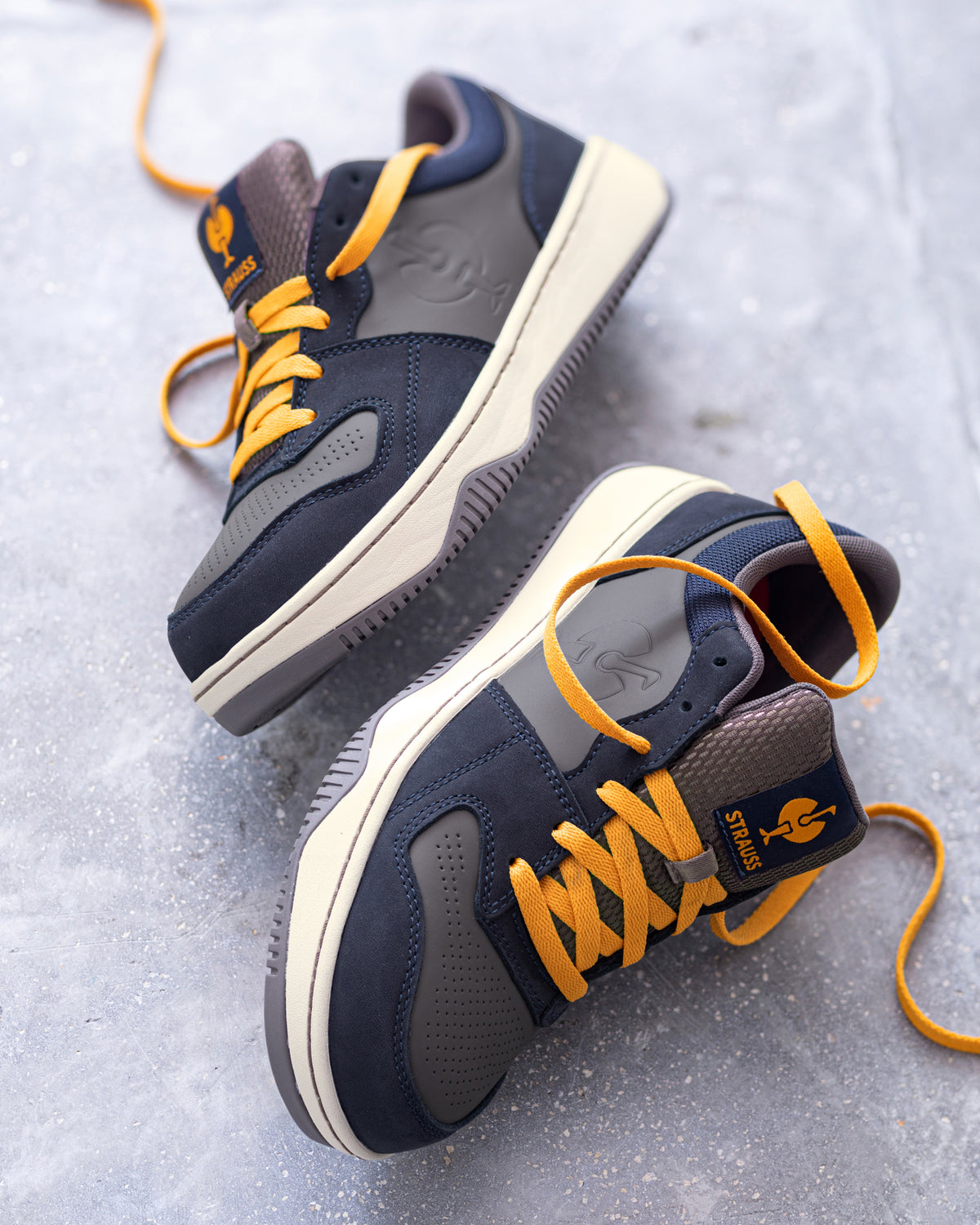 STRAUSS Eindhoven Steel Toe Work Shoe in Nero blue and Stone gray worn in an outdoor work setting