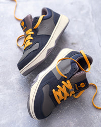 STRAUSS Eindhoven Steel Toe Work Shoe in Nero blue and Stone gray worn in an outdoor work setting