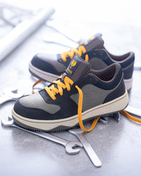 STRAUSS Eindhoven Steel Toe Work Shoe in Nero blue and Stone gray with workwear in a jobsite scene