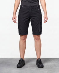 Model wearing Engelbert Strauss women's e.s. trail pure cargo work shorts in black and carbon gray, showing the fit, length, waistband, and front pocket layout of the two-tone women’s cargo work shorts with reinforced utility styling.