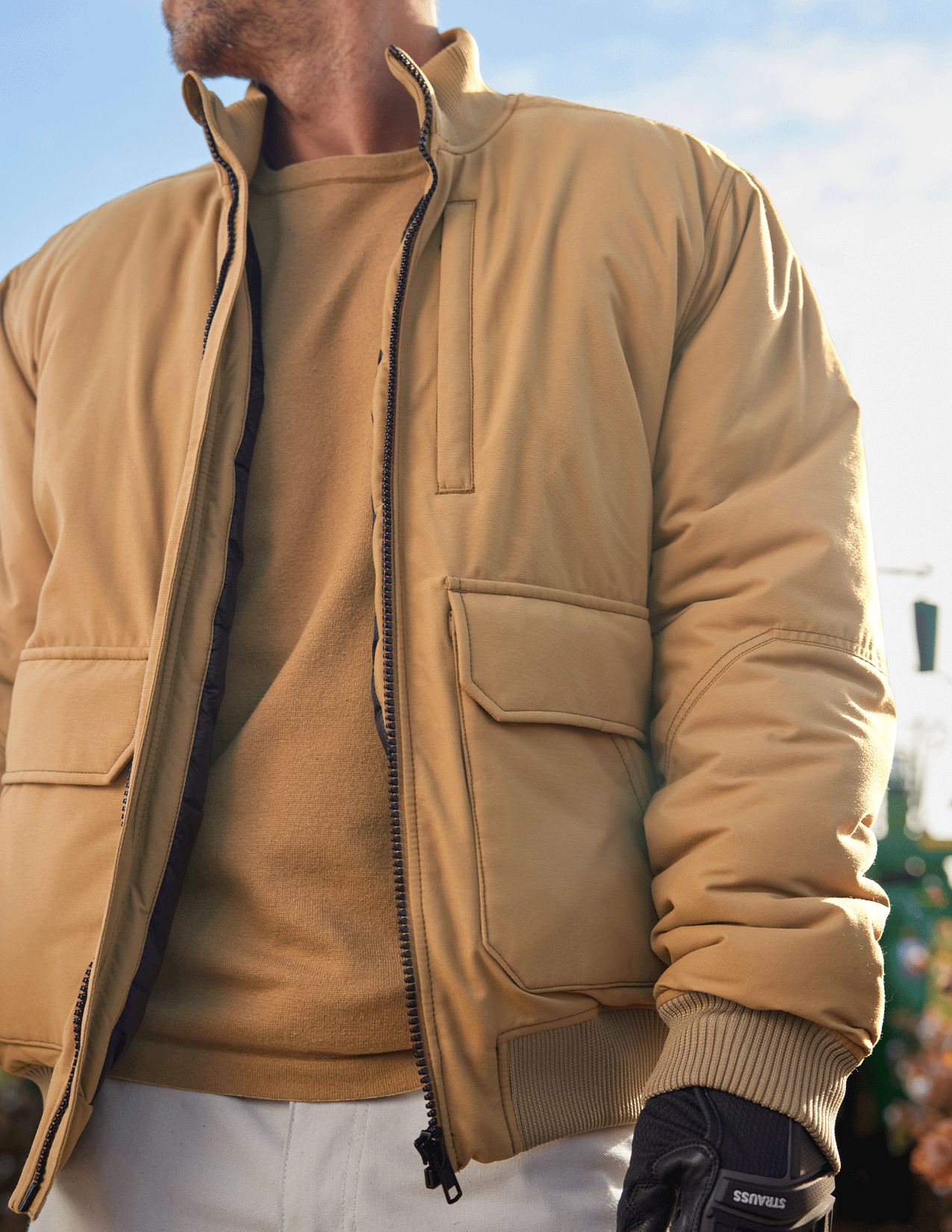 Beige jacket worn by a person with a blurred background