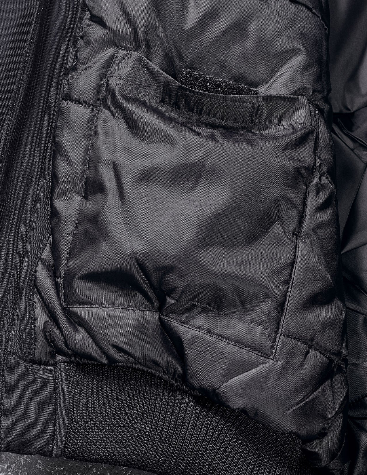 Close-up of a black puffer jacket with a focus on the hood and collar.