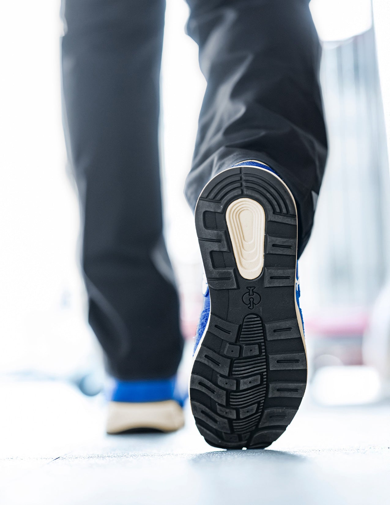 Close-up of a person wearing gentianblue shoes with a white background