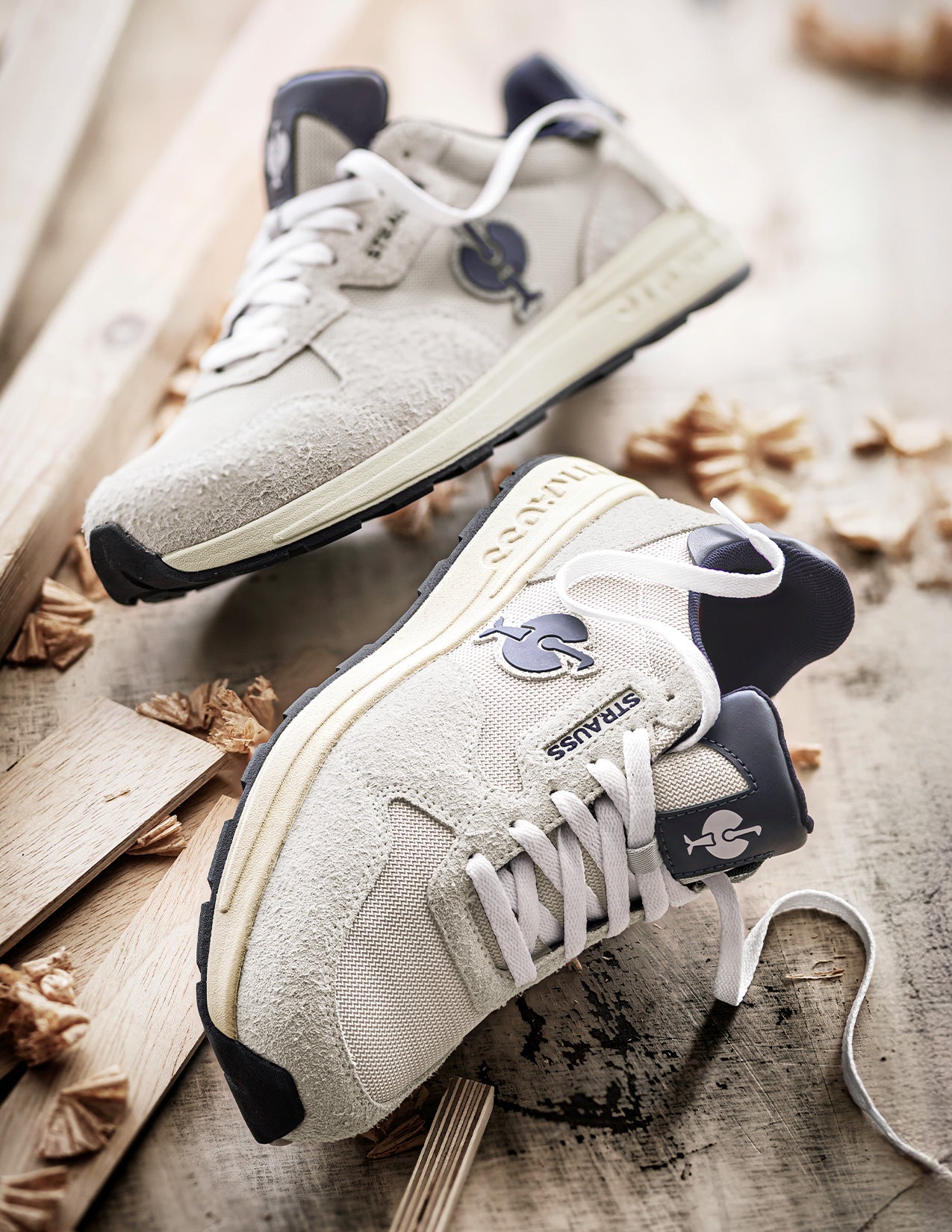 Pair of white sneakers with black accents on a wooden surface